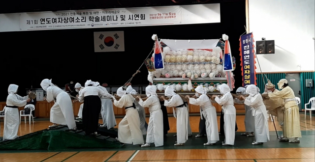 연도여자상여소리 전통상례보존회 회원들이 상여를 들고 솔섬으로 이동하는 장면을 시연하고 있다./주재옥 기자/