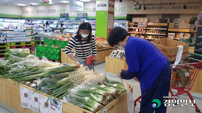 용인 구성농협 하나로마트 내부에 마련된 로컬푸드 직매장. 생산자(오른쪽)가 재배한 상품을 직접 포장해 매대에 진열하면, 소비자(왼쪽)는 막 도착한 신선한 상품을 곧바로 구매할 수 있는 장점을 갖췄다. 용인/황성규기자 homerun@kyeongin.com
