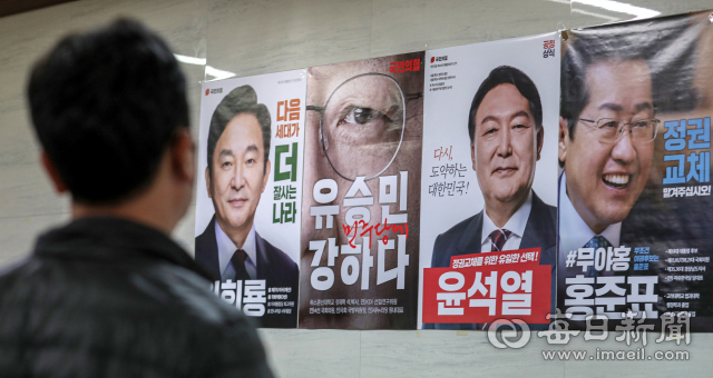 국민의힘 대선후보 선출을 하루 앞둔 4일 국민의힘 대구시당에 붙은 후보자 4명의 포스터를 시당 관계자가 바라보고 있다. 국민의힘은 '당원 투표'와 일반 시민을 대상으로 한 '여론조사'를 50%씩 반영해 5일 오후 2시 반쯤 최종 대선 후보를 발표할 예정이다. 안성완 기자 asw0727@imaeil.com