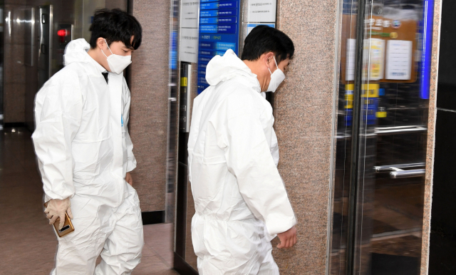 창원시 마산합포구 한 요양병원에서 집단감염이 발생한 가운데 30일 오후 보호복을 입은 방역당국 관계자들이 엘리베이터를 타고 병원으로 들어가고 있다./성승건 기자/
