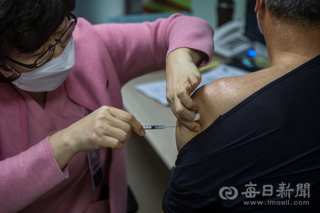 18세 이상 '부스터 샷' 사전예약이 시작된 13일 오전 대구 중구 계명대 동산병원 코로나19 예방 접종실에서 백신 1·2차 접종을 끝낸 시민이 3차 백신 주사를 맞고 있다. 이날 0시 기준 대구지역 3차 백신 접종률은 9.9%를 기록했다. 안성완 기자 asw0727@imaeil.com