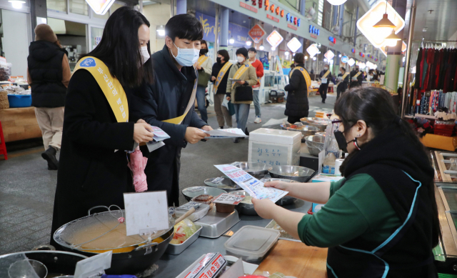 부산 공공배달앱 ‘동백통’의 내년 1월 정식서비스 개시를 앞두고 부산시, 부산경제진흥원, 연제구, 시장상인회 등 관계자들이 16일 오후 연제구 연동골목시장에서 동백통 홍보 캠페인을 벌이고 있다. 강선배 기자 ksun@