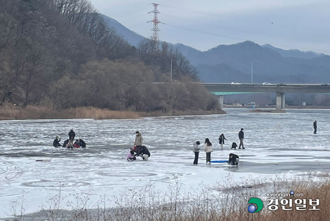 지난 15일 오후 얼어붙은 가평천에서 사람들이 얼음을 지치거나 얼음낚시 등을 하고 있다. 2022.1.15 가평/김민수기자 kms@kyeongin.com