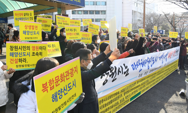 창원발전시민연대 회원들이 창원시의회 앞에서 마산해양신도시 건설 사업 조속 추진을 촉구하고 있다./경남신문 DB/