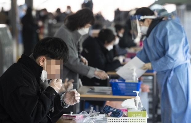 26일 오전 광주 북구 선별진료소에서 ‘자가 진단 키트’ 사용법 안내 영상이 상영되는 가운데 시민들이 신속 항원 검사를 스스로 하고 있다. /최현배 기자choi@kwangju.co.kr