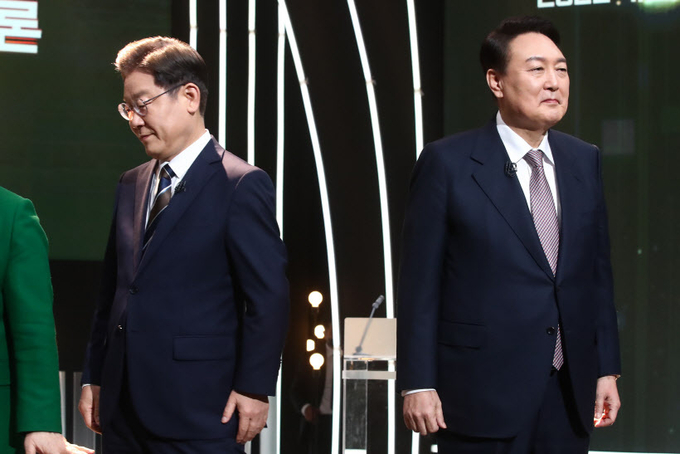 3일 오후 서울 여의도 KBS 공개홀에서 열린 방송 3사 합동 초청 '2022 대선후보 토론'에서 더불어민주당 이재명 대선 후보(왼쪽)가 기념촬영을 마친 뒤 자리로 돌아가고 있다. 오른쪽은 국민의힘 윤석열 대선 후보. 2022.2.3 /국회사진기자단