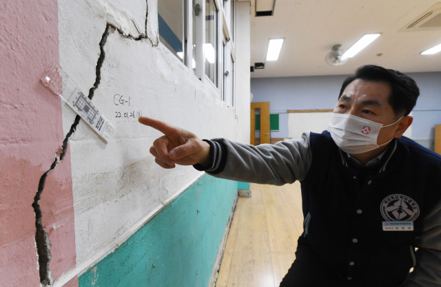 7일 오후 창원시 마산합포구 마산의신여중에서 학교 관계자가 균열이 생긴 교실 벽을 가리키고 있다./성승건 기자/