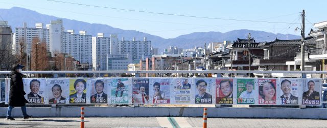 ‘제20대 대통령 선거’를 10일 앞둔 27일 오후 창원시 성산구의 한 도로변에 부착된 선거벽보 앞을 시민이 지나가고 있다./김승권 기자/