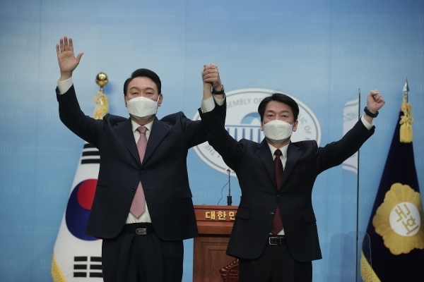 국민의힘 윤석열 대선 후보와 국민의당 안철수 대선 후보가 3일 오전 국회 소통관에서 단일화 기자회견을 마친후 두 손을 잡고 만세를 하고 있다. 국민의힘 선대본부 제공.