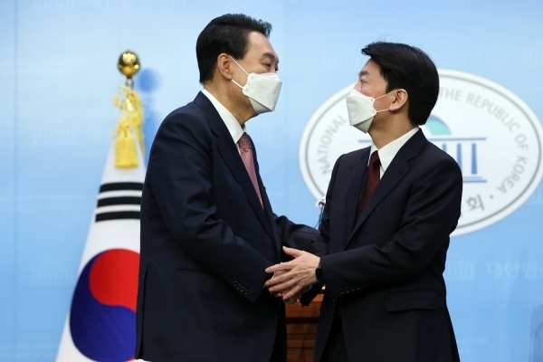 국민의힘 윤석열 대선 후보와 국민의당 안철수 대선 후보가 3일 오전 국회 소통관에서 단일화 기자회견을 마치며 악수를 하고 있다. 국민의힘 선대본부 제공.