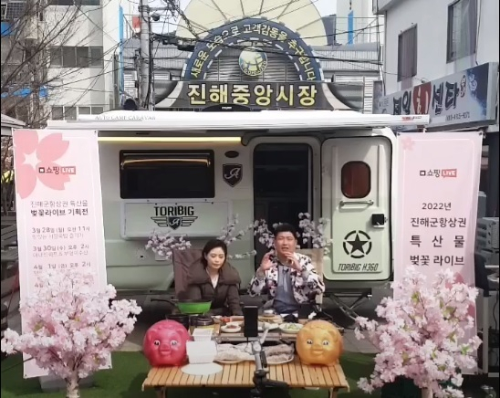 지난 28일 진해 중앙시장 앞에서 소상공인들이 실시간 온라인 판매방식인 ‘벚꽃 라이브 커머스’ 방송을 진행하고 있다./창원시/