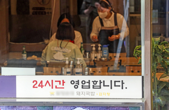 영업시간 제한, 사적모임 인원 제한 등 ‘사회적 거리 두기’ 조치가 모두 해제된 18일 오후 부산 부산진구의 한 식당에 24시간 영업을 알리는 안내문이 붙어 있다. 김종진 기자 kjj1761@