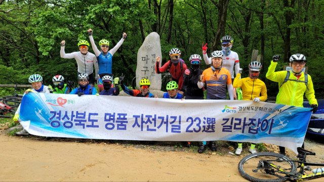 백두대간 마구령 표지석앞에서 경북도 명품 자전거길 탐사팀원들이 힘겹게 오른뒤 잠시 숨을 고르고 있다.