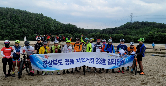 경북도 명품 자전거길 탐사팀원들이 '물위에 떠있는 마을' 영주 무섬마을 외나무다리앞에서 인증샷을 남기고 있다.