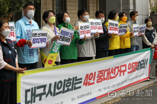 27일 오후 대구시의회 앞에서 기본소득당, 녹색당 등 군소정당과 대구참여연대 관계자들이 4인 중대선거구 의결을 촉구하고 있다. 이날 본회의 표결 결과 재석의원 27명 중 찬성 21명, 반대 4명, 기권 2명으로 4인 선거구 6곳을 2인 선거구로 쪼개는 수정안이 통과됐다. 우태욱 기자 woo@imaeil.com