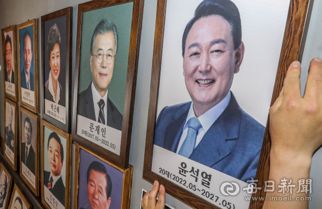윤석열 대통령 취임식을 하루 앞둔 9일 대구 수성구 욱수동 '옛날통닭' 식당에 전시된 '대한민국 역대 대통령' 자리에 식당 관계자가 윤석열 당선인의 사진을 내걸고 있다. 이창곤 옛날통닭 대표는 "식당을 찾는 손님들에게 역대 대통령의 역사를 알리기 위해 사진을 전시하고 있다"고 말했다. 안성완 기자 asw0727@imaeil.com