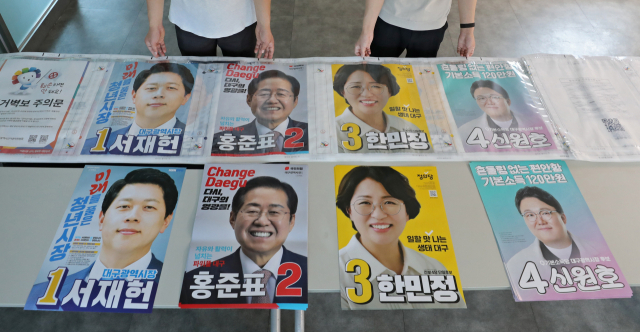 제8회 전국동시지방선거 공식 선거운동을 하루 앞둔 18일 오후 대구 서구 상중이동행정복지센터에서 선거 업무 담당자가 접수된 대구시장 후보자들의 벽보를 검점하고 있다. 김영진 기자 kyjmaeil@imaeil.com