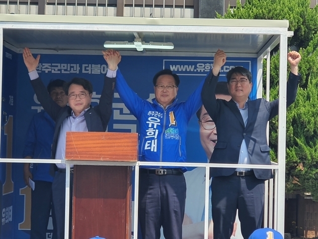 유희대 후보(가운데)가 민주당 경선에서 경쟁했던 이돈승(왼쪽), 두세훈(오른쪽) 경선 후보와 합동유세를 벌이고 있다.
