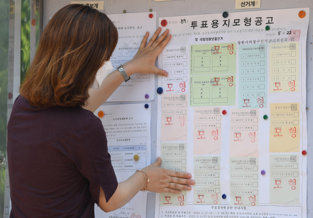 25일 창원시 성산구 경남도선거관리위원회에서 직원이 투표용지 모형을 게시판에 부착하고 있다. 지방선거에서는 광역단체장, 기초단체장, 광역의원, 기초의원, 교육감 등을 한 번에 선출하기 때문에 대부분 색이 다른 투표용지 7장을 한번에 받는다. 국회의원 보궐선거가 함께 실시되는 창원시의창구 유권자는 투표용지를 한 장 더 받게 된다./김승권 기자/