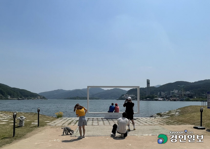 28일 가평군 자라섬 남도 꽃 정원을 찾은 방문객 등이 북한강변에 마련된 포토존에서 사진 촬영을 하고 있다. 가평/김민수기자 kms@kyeongin.com