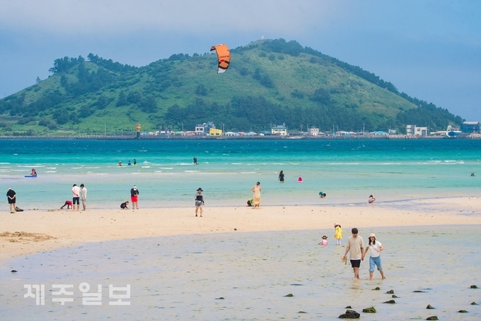 지난 21일 제주시 한림읍 금능해수욕장을 찾은 이용객들이 물놀이를 하며 더위를 식히고 있다. 고봉수 기자 chkbs9898@jejunews.com