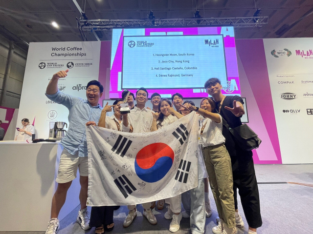 지난 25일(현지 시각) 이탈리아 밀라노에서 열린 2022 월드 컵 테이스터스 챔피언십에서 부산 먼스커피의 문헌관(가운데) 바리스타가 우승했다. SCA 한국챕터 제공