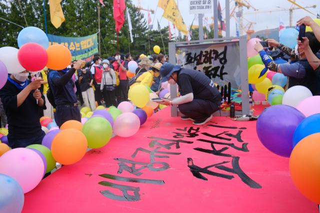 23일 오후 거제 대우조선해양 서문 앞에서 열린 ‘7.23 대우조선 하청노동자 희망버스’ 행사에서 '하청 노동자 희망배 띄우기' 퍼포먼스가 진행되고 있다./김용락 기자/