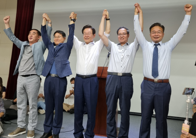 이재명 더불어민주당 당대표 후보(가운데)가 30일 강릉을 방문, 녹색도시체험센터 대강당에서 '개혁정치인 이재명, 허균에게 길을 묻다'라는 제목의 토크 콘서트를 진행한 뒤 민주당 영동지역 위원장들과 손을 들어 인사하고 있다.강릉=고달순기자