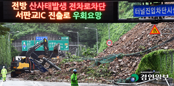 수도권 등 경기지역에 기록적인 폭우가 내린 9일 오전 성남시 분당구 용인서울고속도로 용인방면 하산운터널 입구 경사면 토사가 전날부터 내린 많은 비로 무너져 내려 긴급 복구작업을 벌이고 있다. 2022.8.9 /임열수기자 pplys@kyeongin.com
