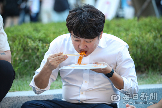 이준석 전 국민의힘 대표가 27일 오후 대구시 북구 DGB대구은행파크 앞에서 열린 '2022 대구 북구 떡볶이 페스티벌'을 찾아 떡볶이를 먹고 있다. 안성완 기자 asw0727@imaeil.com