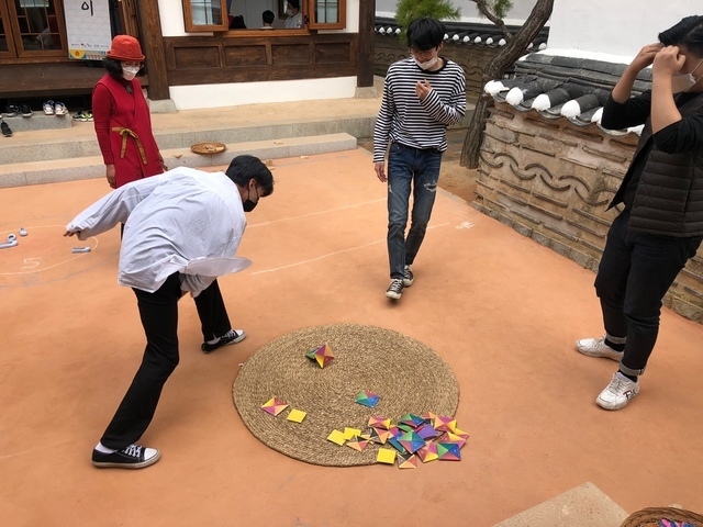 우리놀이터 마루달에서 관광객, 시민 등이 딱지 치기를 하고 있다.