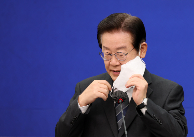 더불어민주당 이재명 대표가 지난 21일 오전 국회 당대표 회의실에서 열린 특별 기자회견에서 발언하기 위해 마스크를 벗고 있다. <사진공동취재단>