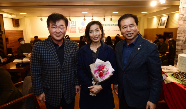 ◇허인구(좌) G1 방송사장과 이해규 춘천연극제이사장이 지난 21일 봄내극장에서 선보인 연극 ‘마주보는 집’의 강원도 초연을 마친후 정은경(가운데) 연출에게 꽃다발을 전달했다. 박승선기자
