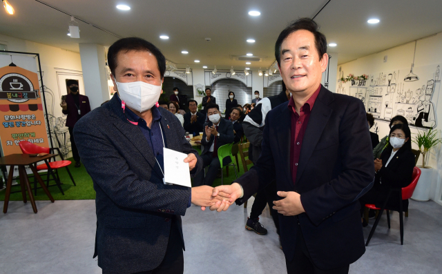 ◇지난 21일 춘천 봄내극장에서 연극 ‘마주보는 집’ 초연 무대에 앞서 박진오 강원일보 사장(우)이 이해규 춘천연극제 이사장에게 연극제 발전을 기원하며 후원금을 전달하고 있다. 박승선기자