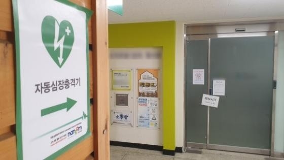 2일 광주시 북구 오치동의 한 아파트 관리사무소에 AED설치 안내는 있지만 점심시간 안내판이 걸려 있는 채 문이 잠겨 있었고(왼쪽) 배터리의 유효기간(점선안)도 5개월 가량 지난 상태였다. /천홍희 기자 strong@kwangju.co.kr