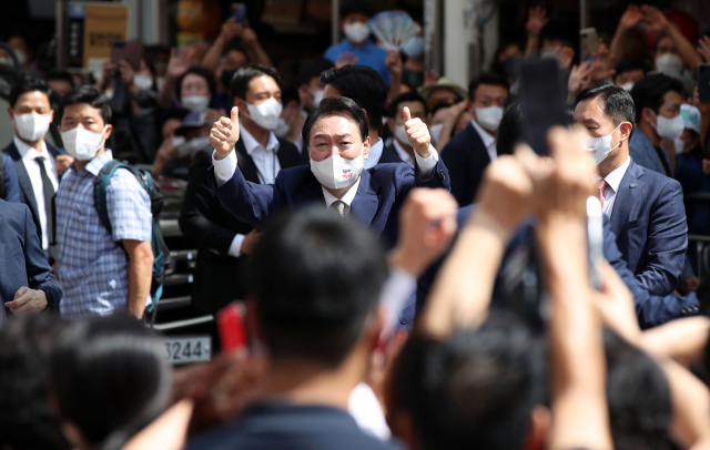 윤석열 대통령이 26일 오후 대구 중구 서문시장을 둘러본 뒤 시민들을 향해 '엄지척'을 하고 있다. 연합뉴스