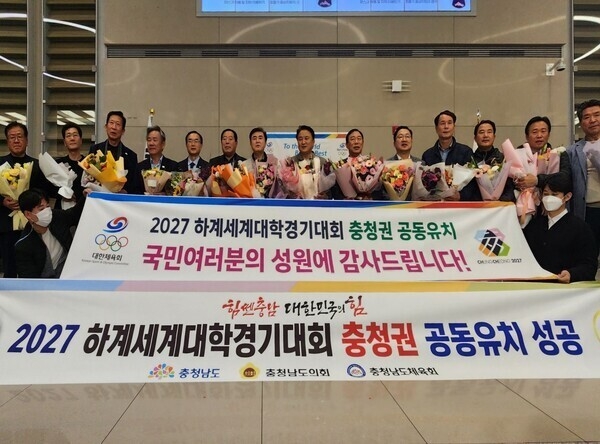 대전ㆍ세종ㆍ충남ㆍ충북 4개 시도지사, 체육회장, 시도의회 의장 등 충청권 대표단(77명)은 2027년 하계 세계대학경기대회 충청권 공동개최 유치를 확정지은 가운데 14일 오후 인천공항에 도착한 후 대한체육회 주관으로 마련된 환영행사에서 귀국보고회를 갖고 기념촬영을 하고 있다. 사진=신익규 기자