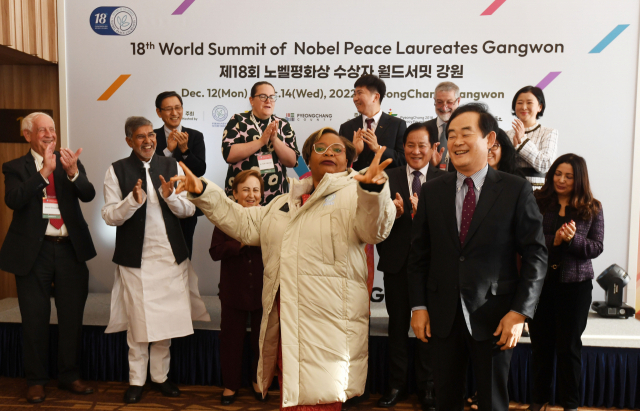 ◇12일 평창 알펜시아에서 열린 2022 노벨평화상 수상자 월드서밋 개막식에 참석한 박진오 강원일보사장(오른쪽)이 리마 보위(2011년 수상·라이베리아)를 비롯한 역대 노벨평화상 수상자들에게 선물로 패딩점퍼를 전달하고 있다. 평창=박승선기자