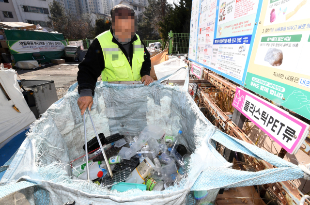 ‘투명 페트병 분리배출제’가 전국 모든 곳에 의무화된 가운데 10일 오후 창원의 한 아파트에서 청소원이 투명페트병이 뒤섞인 플라스틱페트류 분리수거함을 정리하고 있다./성승건 기자/