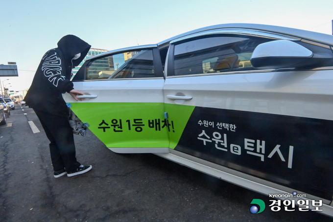 독과점 논란이 일던 카카오T를 견제하기 위해 경기도와 도내 시군 단위에서 만든 공공 호출앱이 저조한 이용률로 힘을 못쓰고 있다. 사진은 19일 오후 수원역 택시승강장에서 한 시민이 수원시 공공 호출앱인 '수원e택시' 광고가 부착된 택시에 탑승하고 있다. 2023.2.19. /김명년기자 kmn@kyeongin.com