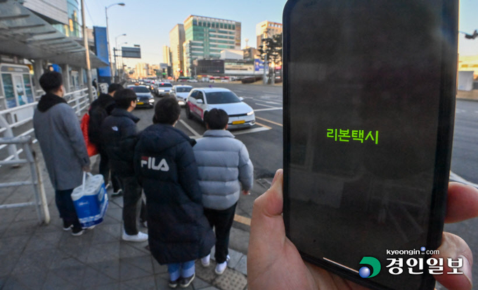 독과점 논란이 일던 카카오T를 견제하기 위해 경기도와 도내 시군 단위에서 만든 공공 호출앱이 저조한 이용률로 힘을 못쓰고 있다. 사진은 19일 오후 수원역 택시승강장에서 리본택시 어플 화면 뒤로 시민들이 택시에 탑승하고 있다. 2023.2.19. /김명년기자 kmn@kyeongin.com