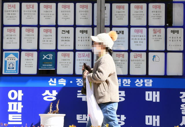 27일 한 시민이 창원의 한 상가 공인중개사 사무소에 붙은 아파트 매매 정보판 앞을 지나가고 있다./김승권 기자/