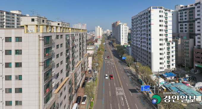 19일 오후 인천시 미추홀구 경인로(가운데 도로)를 사이에 두고 붉은 바탕으로 제작된 '전세사기 구제' 요구 현수막이 설치된 주상복합 건물(왼쪽 건물과 오른쪽 중앙건물)들이 양쪽에 위치해 있다. 2023.4.19 /조재현기자 jhc@kyeongin.com