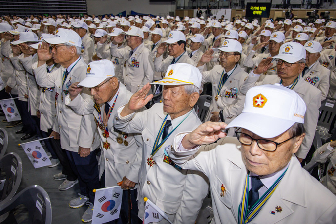 25일 오전 서울 중구 장충체육관에서 열린 6.25 73주년 행사에 참석한 참전 용사들이 국가보훈부에서 올해부터 지급한 '영웅의 제복'을 입고 국기에 경례하고 있다. 2023.6.25 /연합뉴스