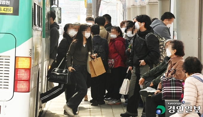 사진은 수원시내 한 버스정류장에서 마스크를 쓴 시민들이 버스에 탑승하고 있는 모습. /경인일보DB