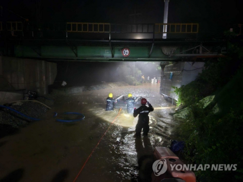 ◇지난 14일 오후 11시께 강원 영월군 연하리의 침수된 도로에서 소방대원들이 주민 구조작업을 하고 있다.사진=연합뉴스