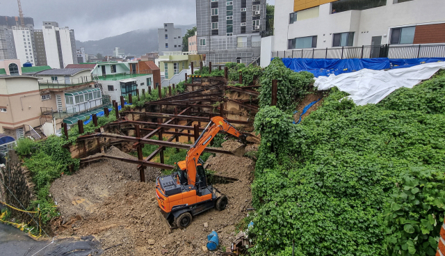 부산 부산진구 초읍동 한 공사 현장에서 18일 붕괴된 경사면 복구 작업이 진행되고 있다. 이곳에선 지난 16일 폭우로 토사가 쏟아져 인근 주민 44명이 긴급 대피했다. 김종진 기자 kjj1761@
