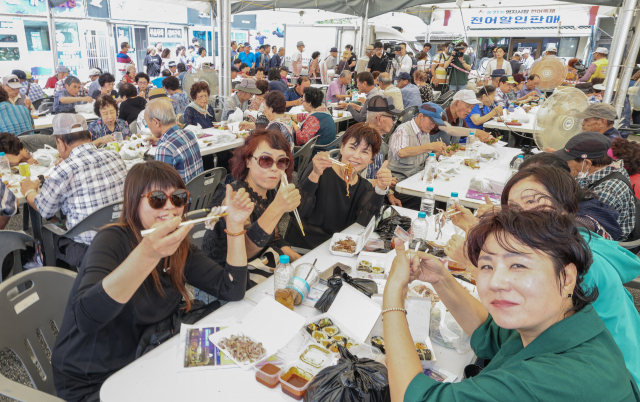 29일 부산 강서구 명지시장에서 열린 ‘명지시장 전어축제’를 찾은 방문객들이 전어회를 먹고 있다. 김종진 기자 kjj1761@