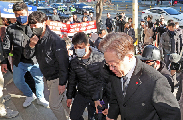 이재명 더불어민주당 대표가 13일 부산 부산진구 범천동 더불어민주당 부산시당 앞에서 열린 산업은행 부산 이전을 촉구하는 시민단체 기자회견장을 지나 시당 건물로 들어서고 있다. 이재찬 기자 chan@