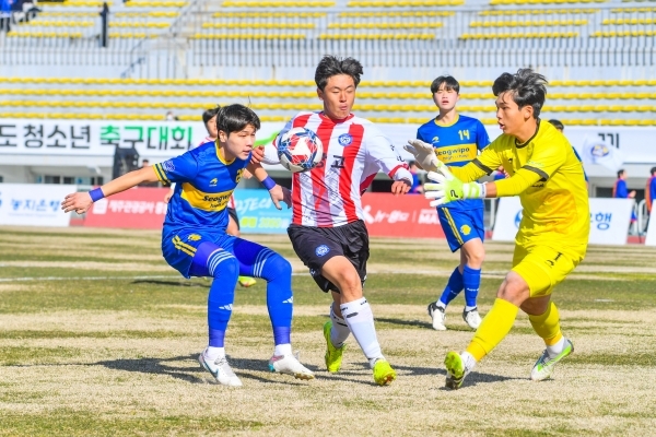서귀포고 선수(파란색)와 제주중앙고 선수(빨간 줄무늬)가 21일 예선 첫 경기에서 서귀포고 키퍼 앞에서 볼 다툼을 벌이고 있다.
